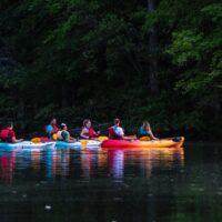 people-on-kayak-boat-near-green-leafed-trees-1497735